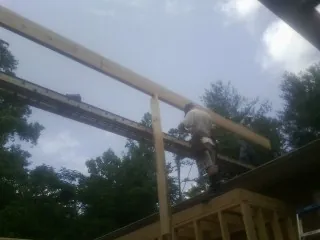 Carpenter setting a ridge beam over a new addition frame — Ice Dam Removal by Roofing Brothers in Kanawha