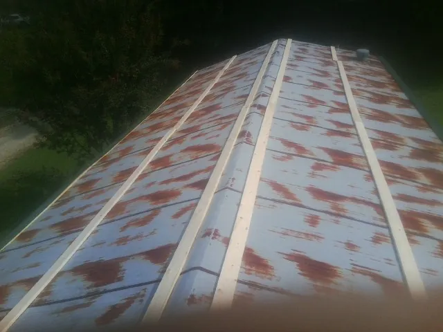 Rusted metal roof panels with new wood purlins before replacement — Storm Damage Roof Repair in Kanawha by Roofing Brothers