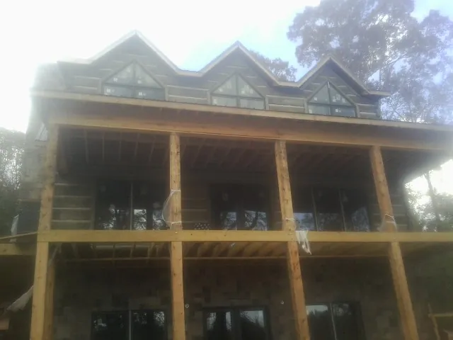 Dormers and porch framing on a large log home under construction — Roof Coating work by our crew in Kanawha