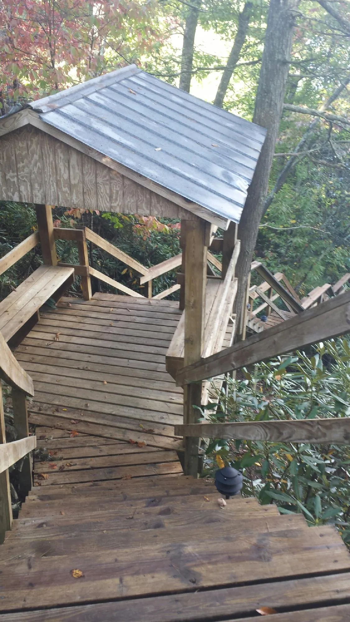 Metal roofed shelter over wooden steps on a wooded walkway — Skylight Repair & Installation work by our crew in Kanawha