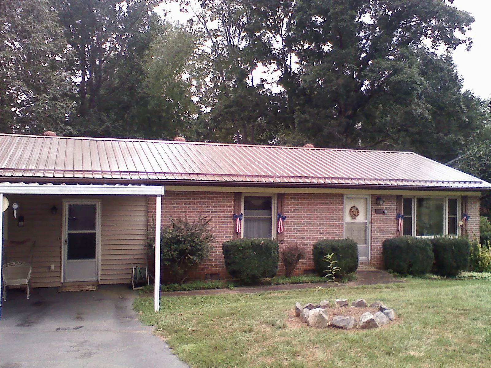 Bronze metal roof and carport on a brick ranch home — Roof Repair work by our crew in Kanawha